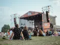 Widownia siedzi na trawie przed sceną podczas Enea Festival Baranowo.