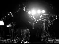 Perkusista w kapeluszu gra na bębnach, tworząc magiczny **ambient** na scenie.