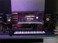 Studio nagraniowe z monitorem "Fabryka Hitów", klawiaturą, mikrofonem i głośnikami. Idealne miejsce dla polskich wytwórni muzycznych.