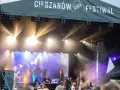Zespół gra na scenie podczas Cieszanów Rock Festiwal. W tle wielki ekran z wizerunkiem wokalistki i reflektory.