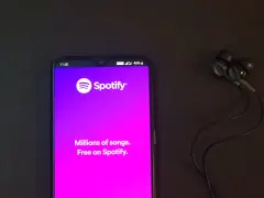 Telefon z aplikacją Spotify i słuchawkami. Idealne do słuchania wzruszających piosenek o przyjaźni.