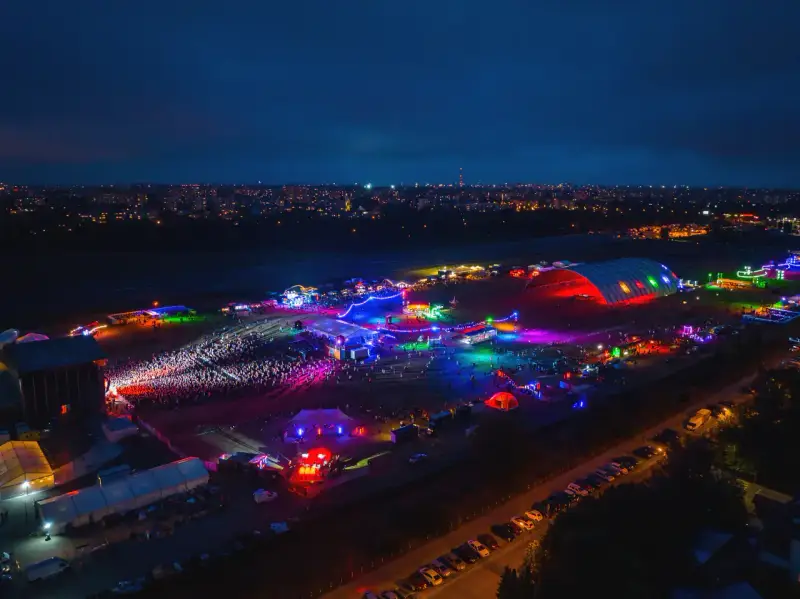 Nocne, kolorowe światła rozświetlają teren festiwalu na powietrzu. Tłumy bawią się pod wielkim, podświetlonym namiotem i na otwartych scenach.